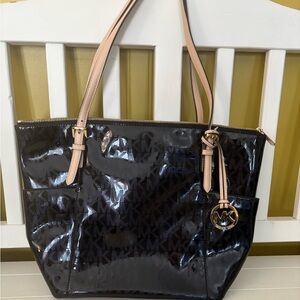 Michael Kors black patent leather shoulder bag with beige straps.